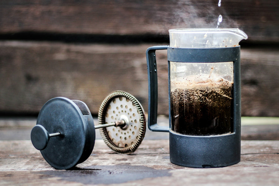 French press of coffee on a rustic wooden table