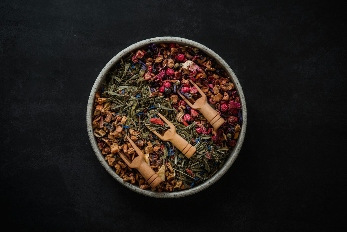Loose leaf tea blend in a bowl with wooden scoops