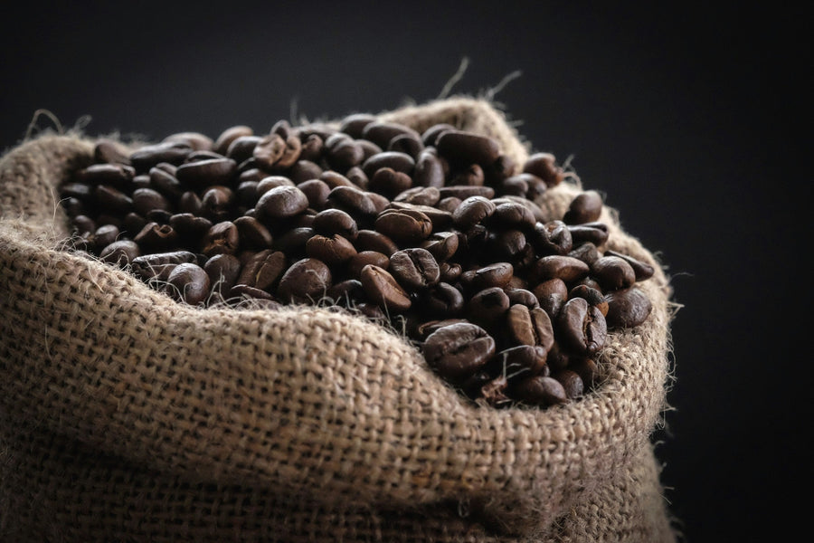Whole roasted coffee beans in a burlap sack