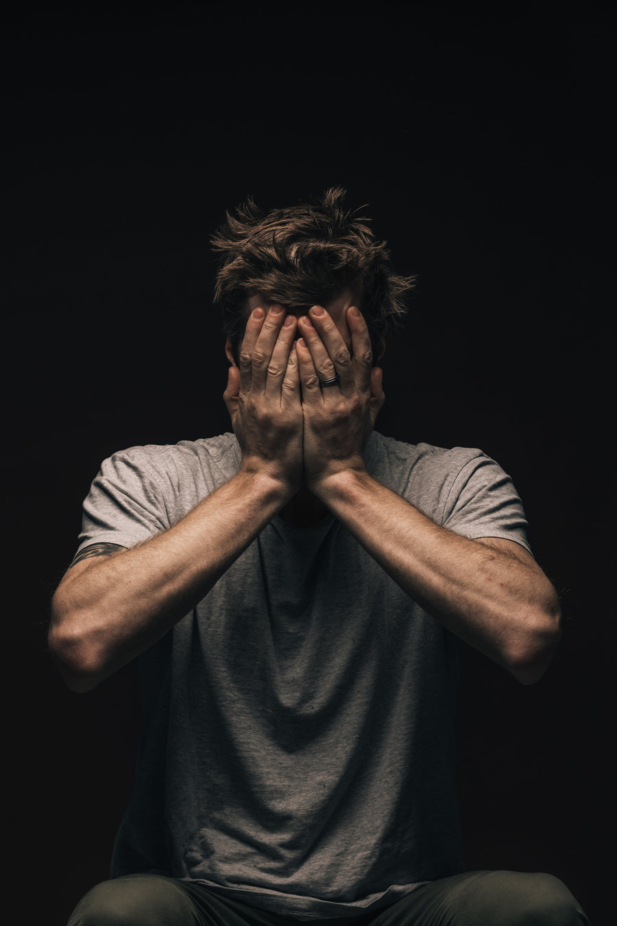 Man covering his face with his hands
