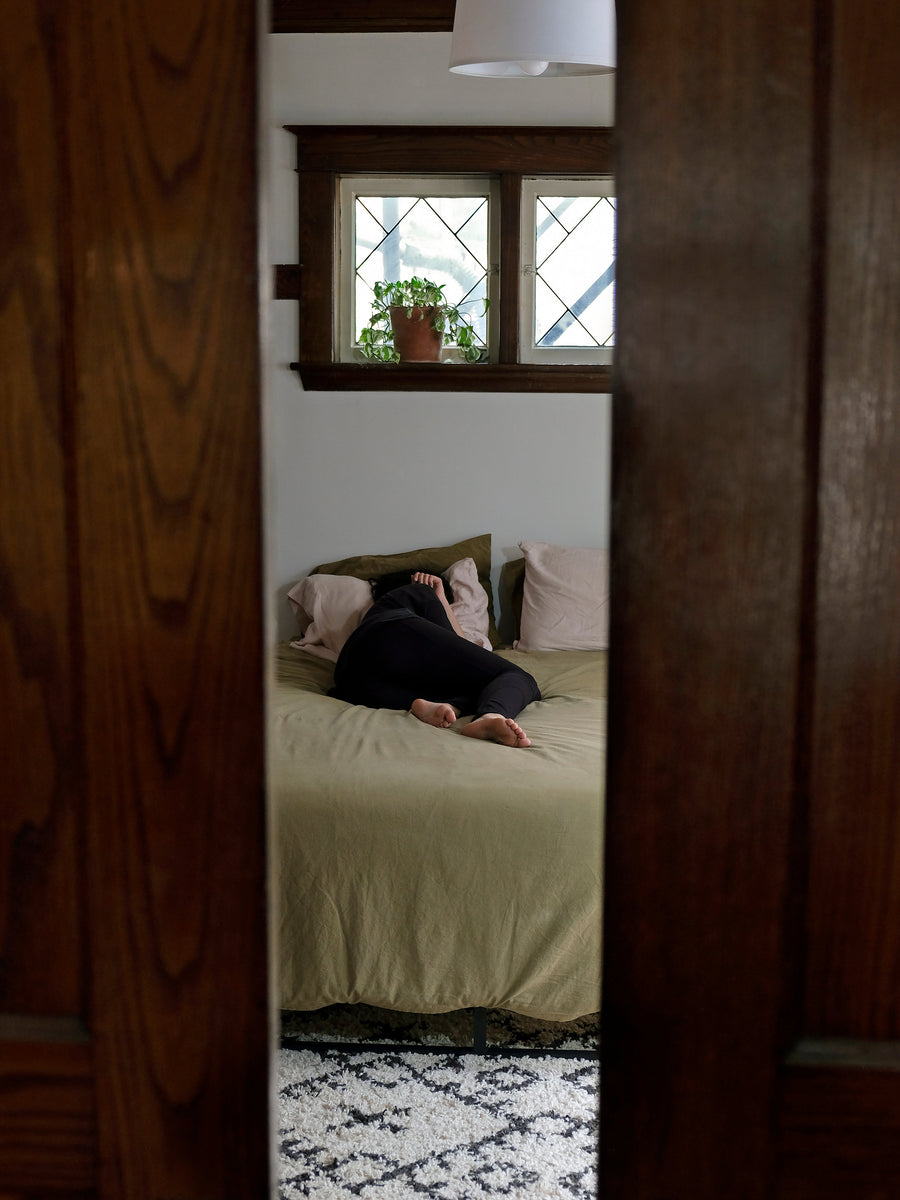 Person sleeping in bed, seen between open doors